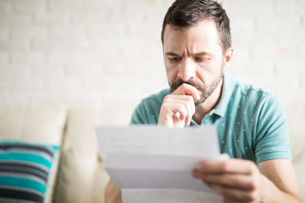 man reviewing home warranty to determine if it covers new HVAC system