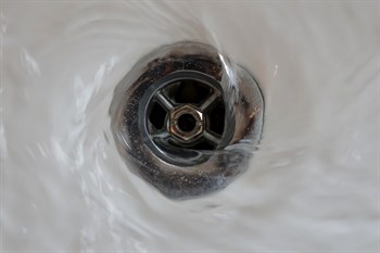 Water circling around a drain as it flows out of the sink