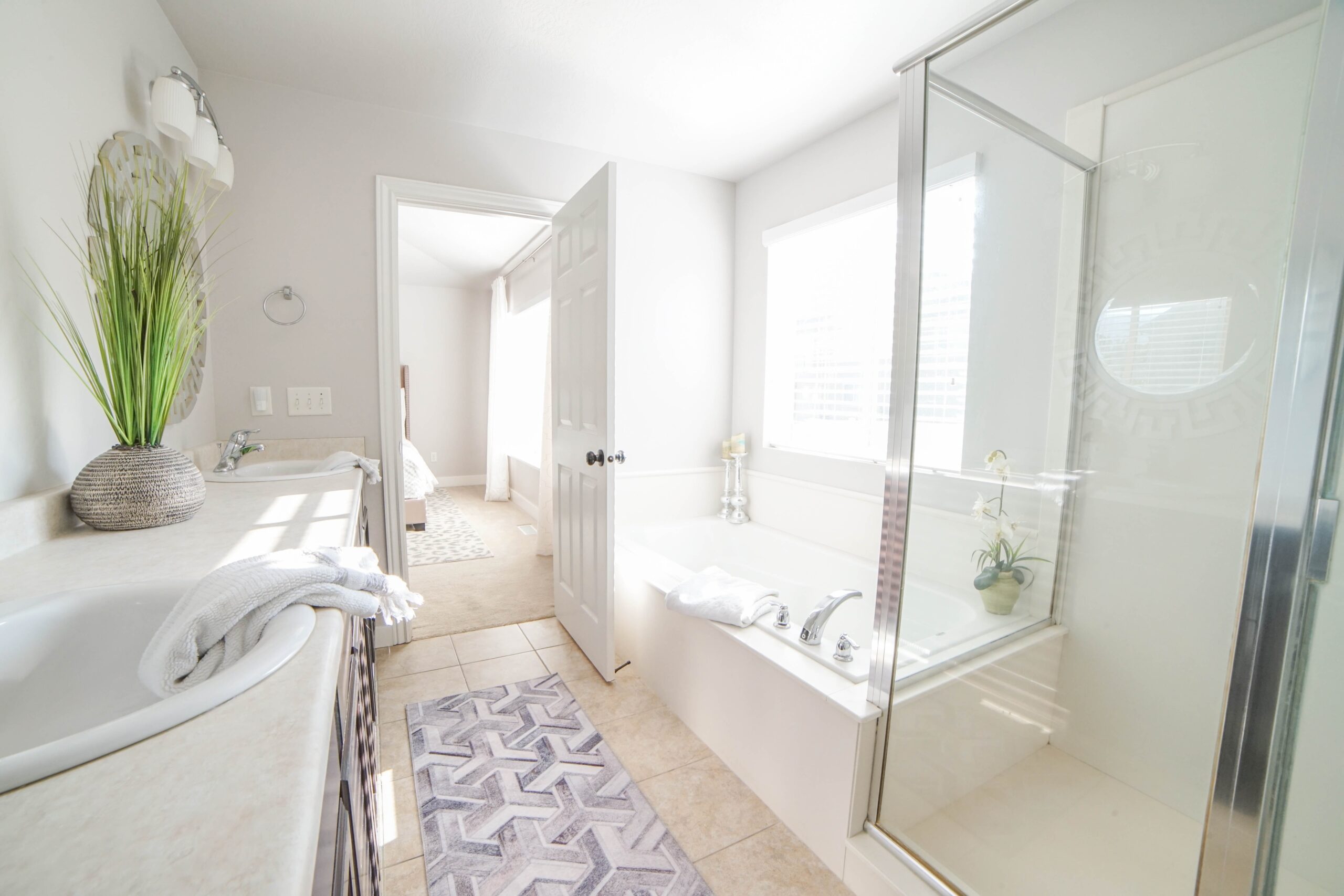 upgraded enclosed shower and large bathtub in bright bathroom
